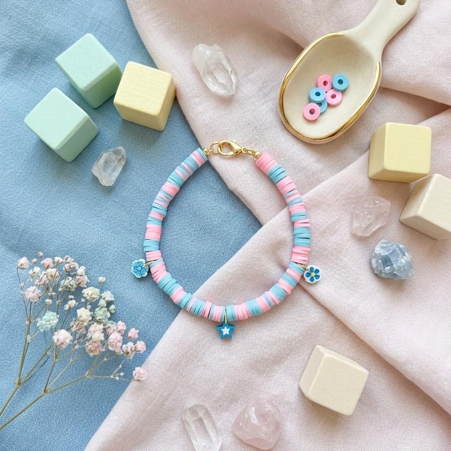 Bracelet heishi bleu et rose orné de charms étoile et fleurs