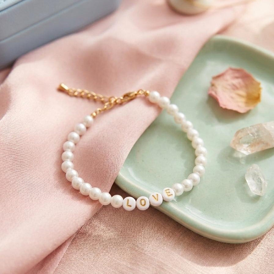 Bracelet en perles de culture blanches avec lettres LOVE dorées